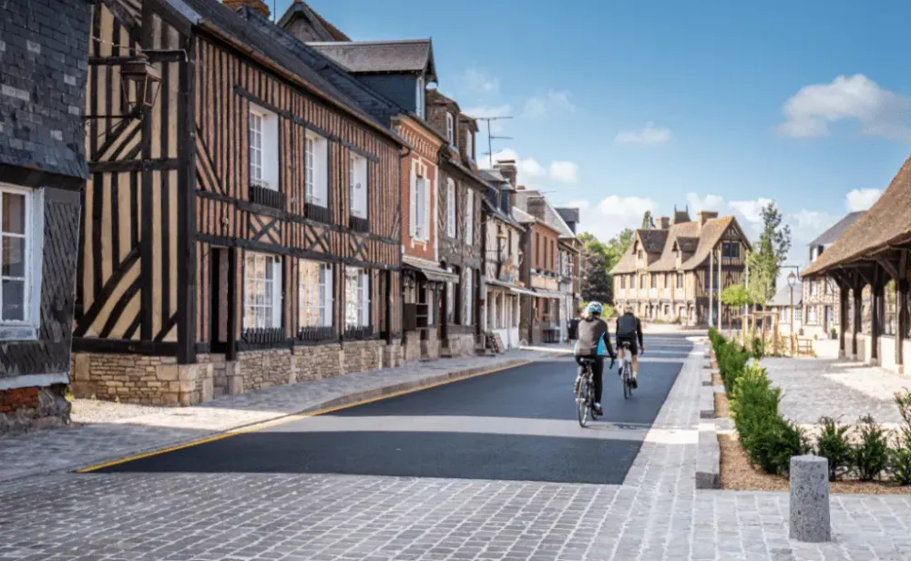 Centre ville de Beuvron-en-Auge avec des cyclistes